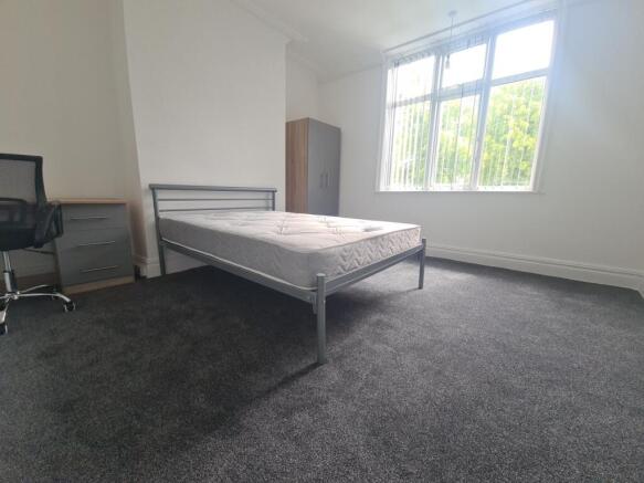 A bright and tidy bedroom featuring a double be...