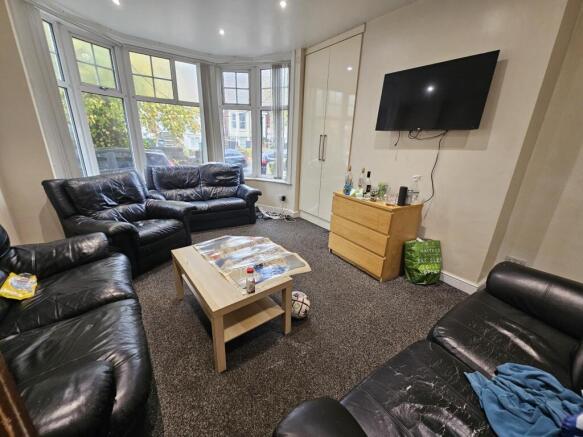 A spacious and well-lit living room featuring c...