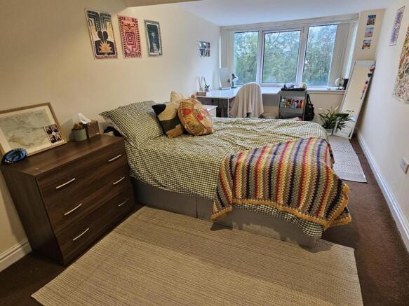 A spacious and well-lit master bedroom featurin...