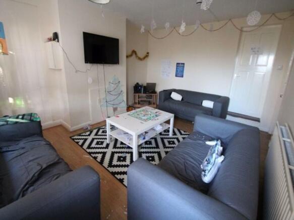 A spacious and well-lit living room featuring c...