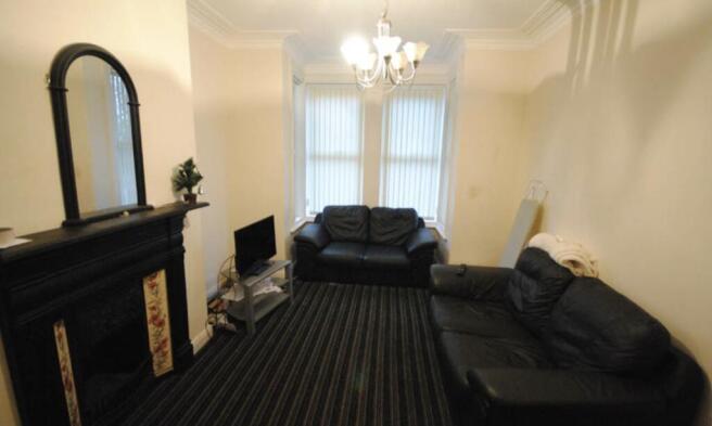 A spacious and well-lit living room featuring a...