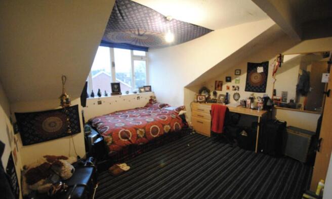 A spacious master bedroom featuring a comfortab...