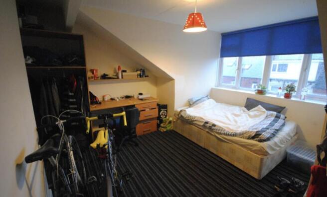 A cozy bedroom featuring a neatly made double b...