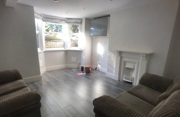 A bright, spacious living room with large windo...