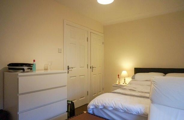 A clean and well-lit double bedroom featuring a...