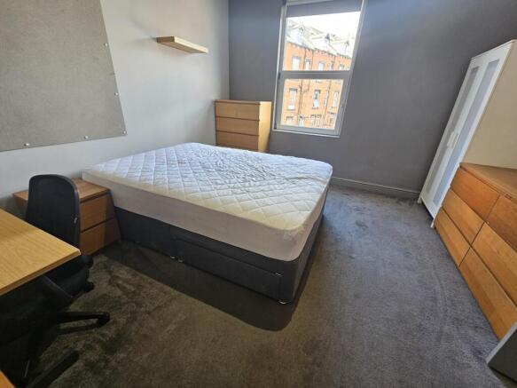 A spacious double bedroom featuring a comfortab...
