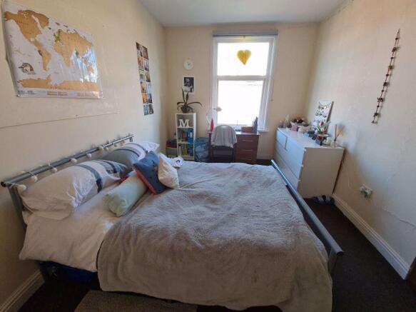 A spacious master bedroom featuring a double be...