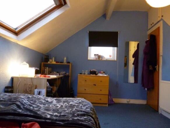 A cozy bedroom with a sloped ceiling and natura...