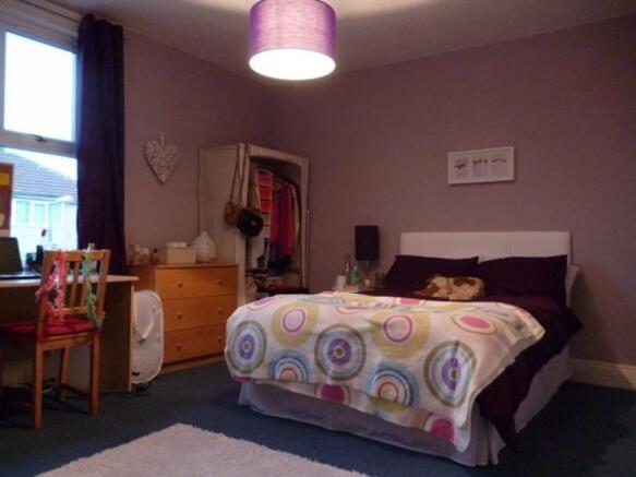 A well-maintained bedroom featuring a large bed...