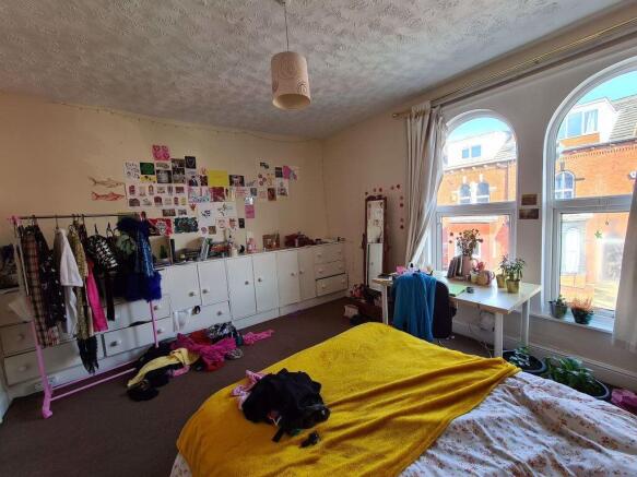 A cozy bedroom featuring a neatly made bed, nat...