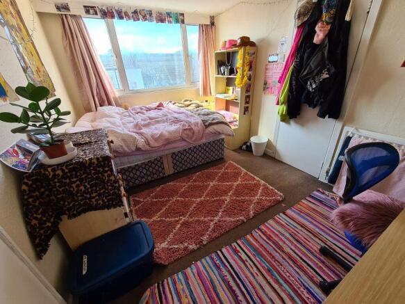 A bright and cozy master bedroom with a large w...