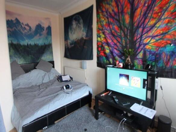 A spacious master bedroom featuring a large bed...