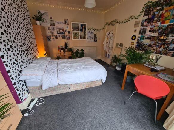 A well-lit, inviting master bedroom featuring a...