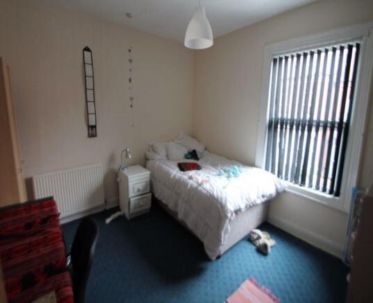 A bright and cozy bedroom featuring a comfortab...