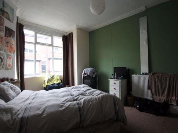 A spacious master bedroom featuring a large bed...