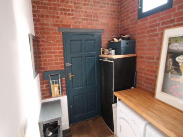 A well-lit kitchen area featuring a wooden coun...