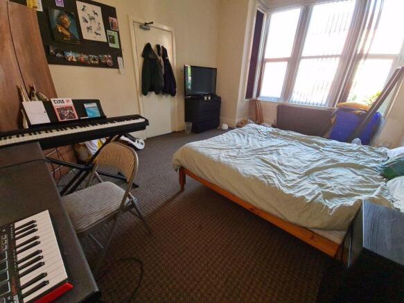 A spacious, well-lit master bedroom featuring a...