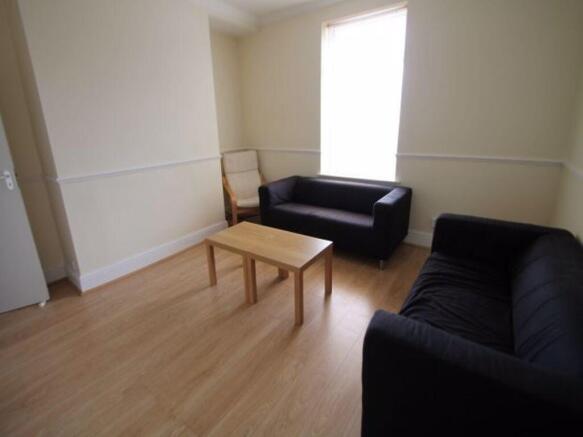A well-lit, tidy living room featuring two comf...
