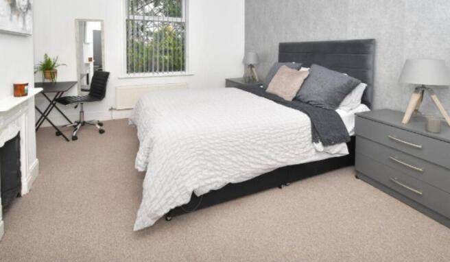 A modern, well-lit bedroom featuring a large be...