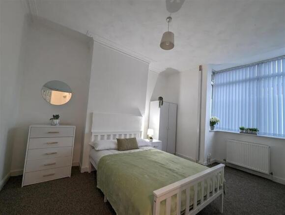 A bright and tidy bedroom with a comfortable do...