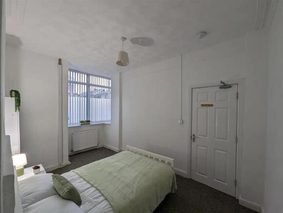 A bright, tidy bedroom featuring a single bed w...