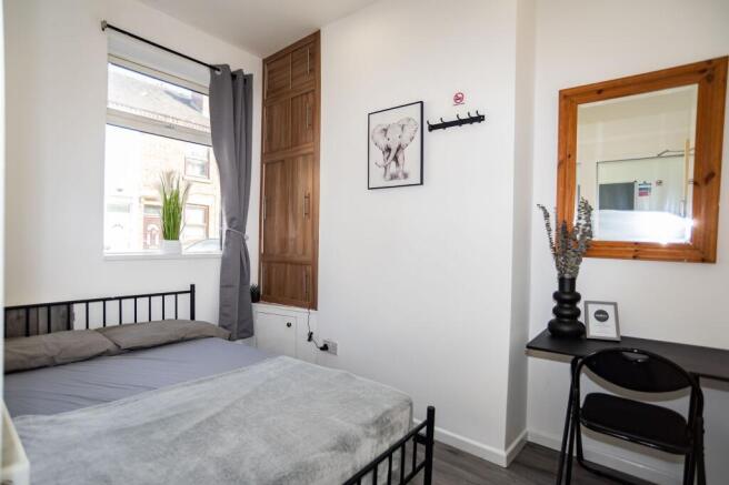 Bright and cozy bedroom featuring a comfortable...