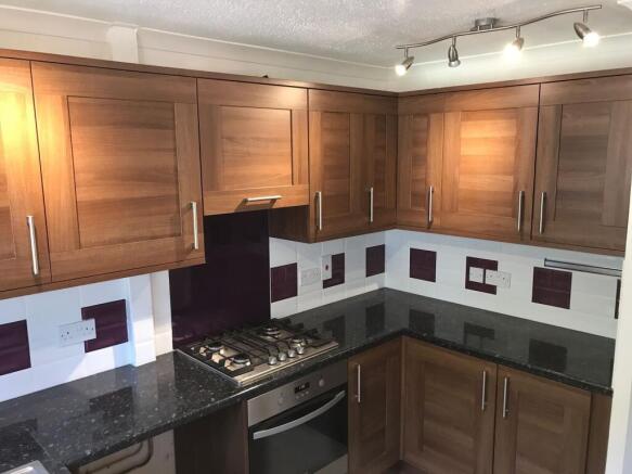 A modern kitchen featuring wooden cabinets, a s...