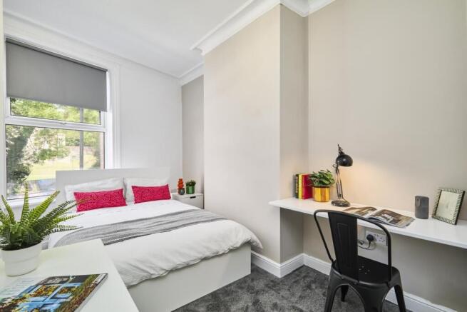 Bright and airy master bedroom with a comfortab...