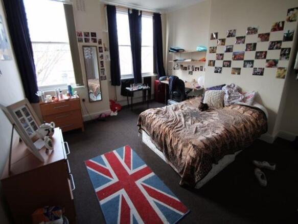 A well-kept double bedroom featuring a cozy bed...