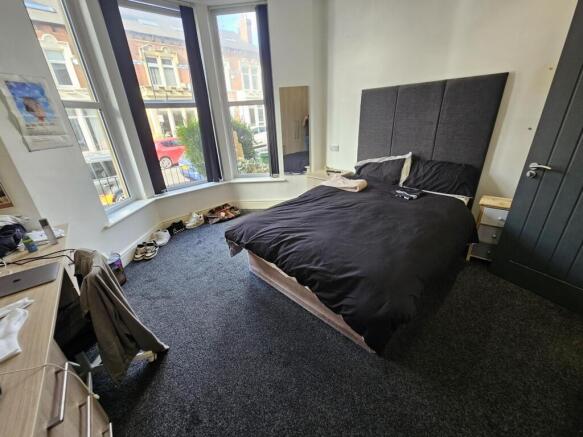 A spacious and well-lit master bedroom with a c...