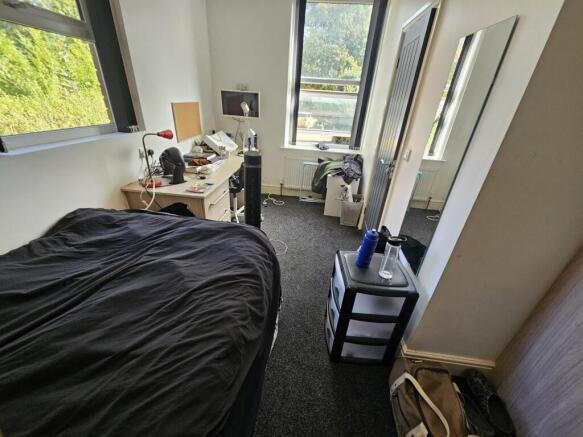 A cozy student bedroom featuring a double bed, ...