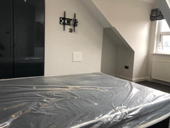 A well-lit bedroom with large windows and moder...