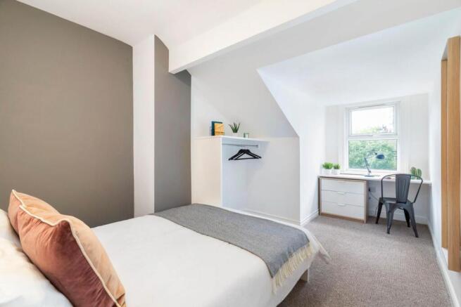 Bright and tidy bedroom featuring a comfortable...