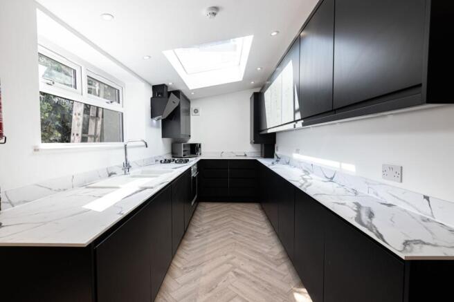 Modern and sleek kitchen featuring black cabine...
