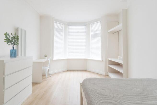 Bright and airy bedroom with large windows dres...