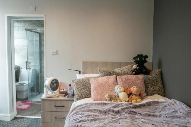 A spacious and tidy master bedroom featuring a ...