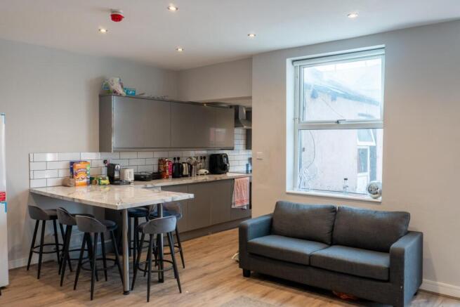 A modern, well-lit living room featuring a dark...