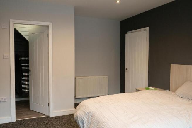 A well-maintained bedroom with a tidy bed, neut...