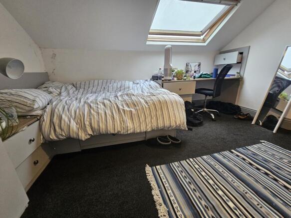 A bright, well-maintained bedroom with a single...