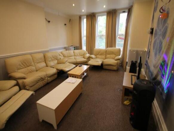 A spacious, well-lit living room featuring comf...