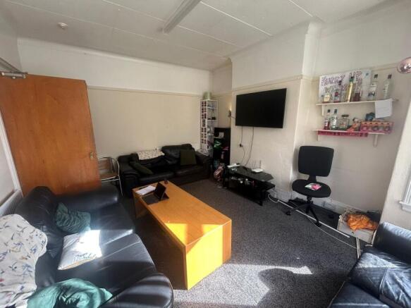 A spacious and well-lit living room featuring m...