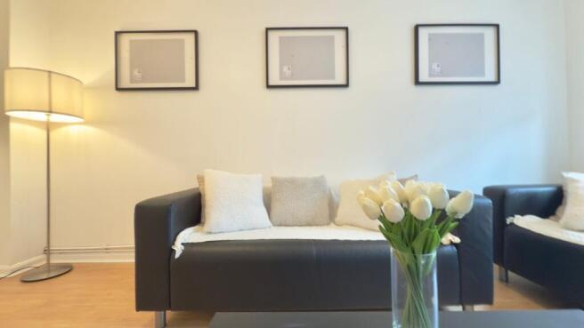 A modern, well-lit living room featuring two co...