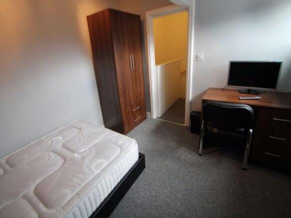 A neat and functional single bedroom featuring ...