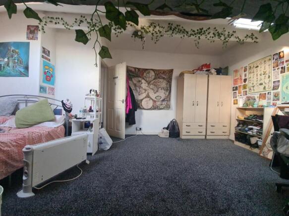 A cozy bedroom featuring a comfortable single b...