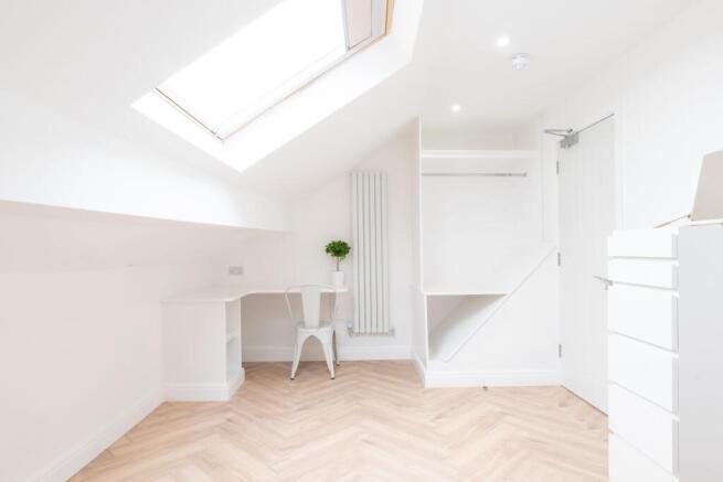 Bright and airy bedroom with a skylight allowin...