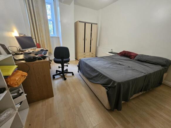 A spacious master bedroom featuring a large bed...