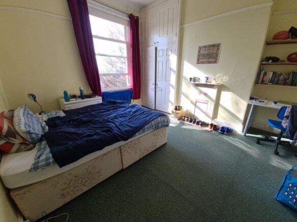 A cozy bedroom featuring a single bed, with a w...