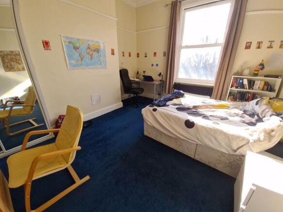 A cozy bedroom with a large window allowing ple...