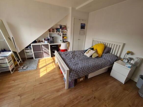 A cozy single bedroom featuring a neatly made b...