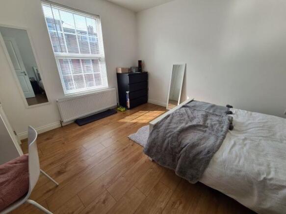 A cozy and well-lit bedroom featuring a double ...